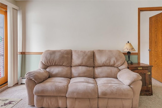 living area with a baseboard radiator and light colored carpet