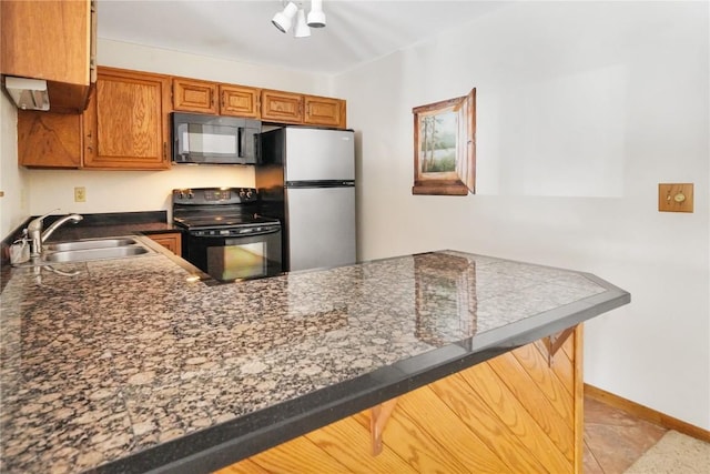 89200 Ryan Gulch Rd Unit 208, Silverthorne, CO 80498 - kitchen featuring black appliances, a sink, dark countertops, a peninsula, and brown cabinetry