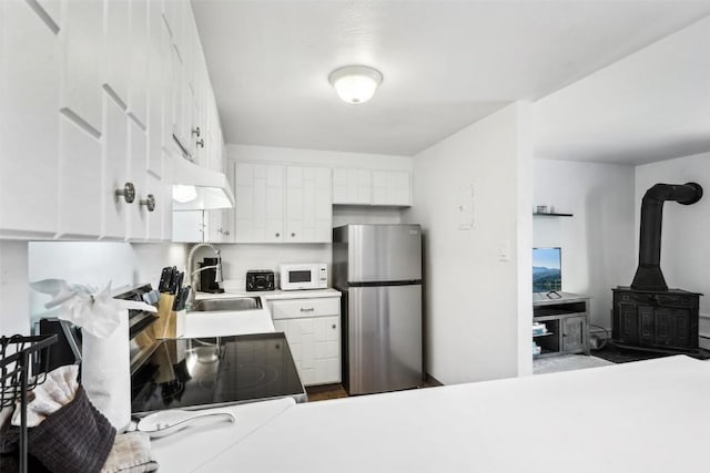 180 Evergreen Rd Unit 102, Dillon, CO 80435 - kitchen with light countertops, a sink, freestanding refrigerator, white microwave, and white cabinetry