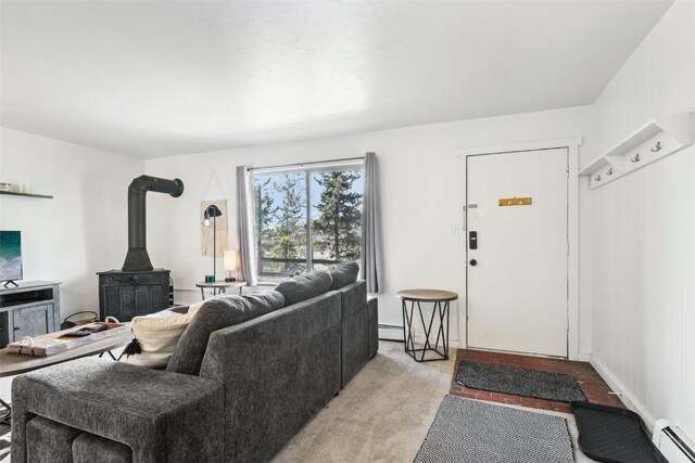 180 Evergreen Rd Unit 102, Dillon, CO 80435 - living room with baseboard heating, a baseboard heating unit, a wood stove, and light colored carpet
