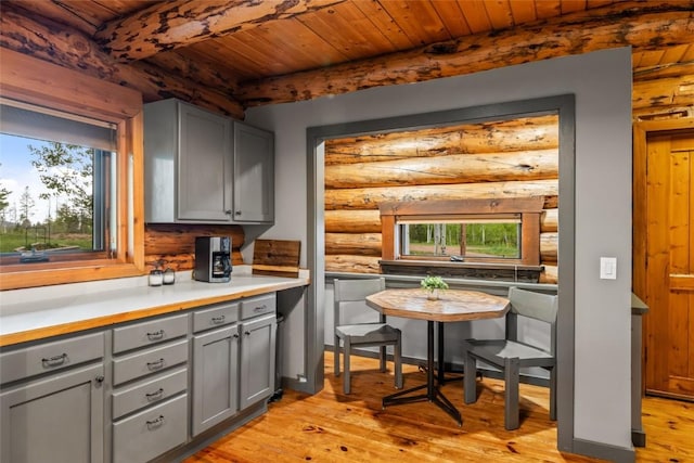 33000 Maricopa Trl, Oak Creek, CO 80467 - kitchen featuring gray cabinetry, log walls, a wood ceiling with exposed beams, light wood-type flooring, and light countertops
