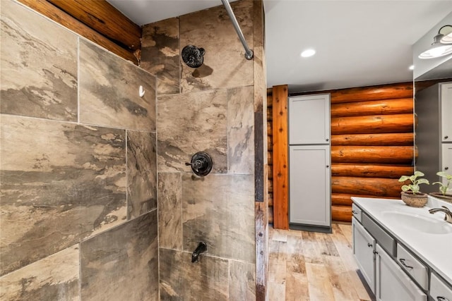 33000 Maricopa Trl, Oak Creek, CO 80467 - bathroom featuring log walls, tiled shower, wood finished floors, vanity, and recessed lighting