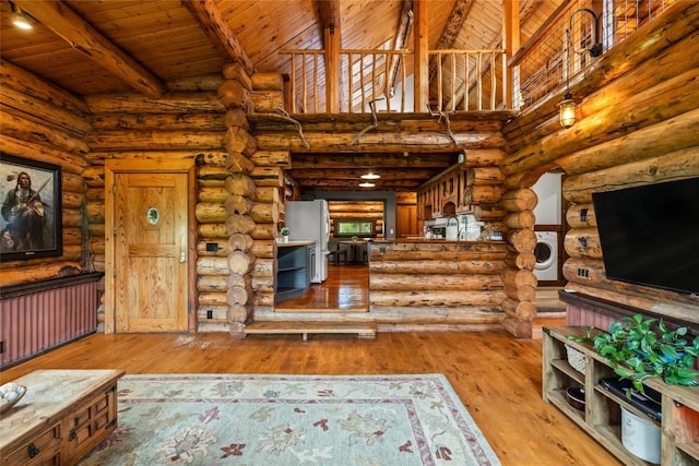 33000 Maricopa Trl, Oak Creek, CO 80467 - unfurnished living room featuring washer / dryer, a wood ceiling with exposed beams, wood-type flooring, log walls, and a high ceiling