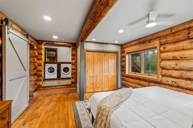 33000 Maricopa Trl, Oak Creek, CO 80467 - bedroom with a barn door, rustic walls, washing machine and clothes dryer, recessed lighting, and light wood-type flooring