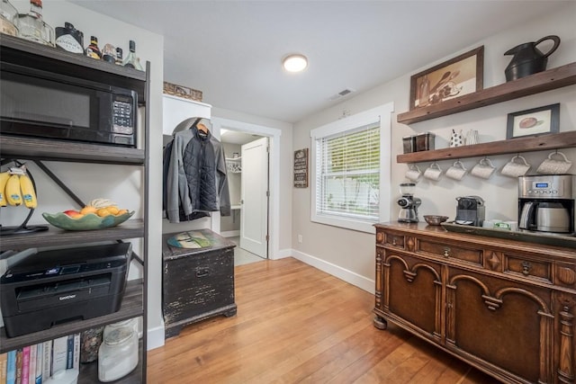 464 8th St, Steamboat Springs, CO 80487 - kitchen with baseboards, light wood-style flooring, black microwave, and open shelves