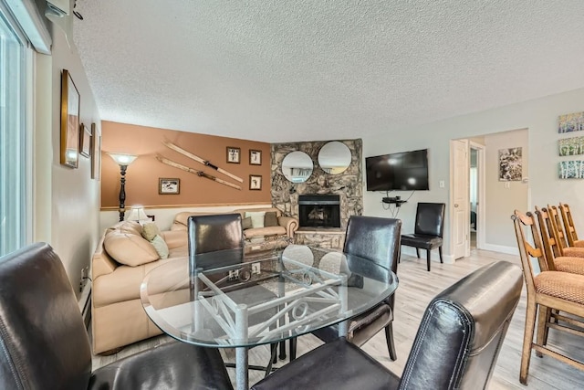 412 S Main St Unit 215, Breckenridge, CO 80424 - living room with light wood-style flooring, a stone fireplace, and a textured ceiling