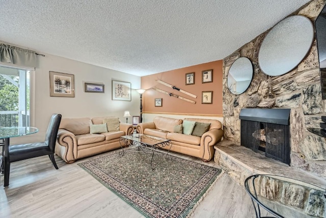 412 S Main St Unit 215, Breckenridge, CO 80424 - living room featuring a stone fireplace, wood finished floors, and a textured ceiling
