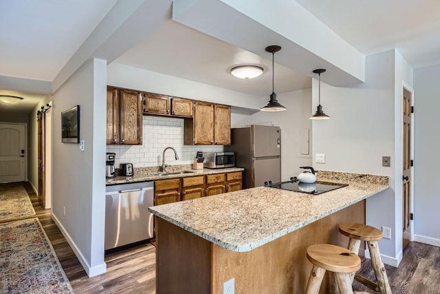 325 Four Oclock Rd Unit E202, Breckenridge, CO 80424 - kitchen with appliances with stainless steel finishes, dark wood-style flooring, a peninsula, backsplash, and a kitchen bar