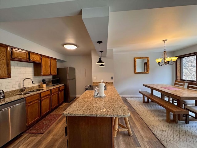 325 Four Oclock Rd Unit E202, Breckenridge, CO 80424 - kitchen featuring stainless steel appliances, dark wood-style floors, decorative backsplash, a chandelier, and light stone countertops