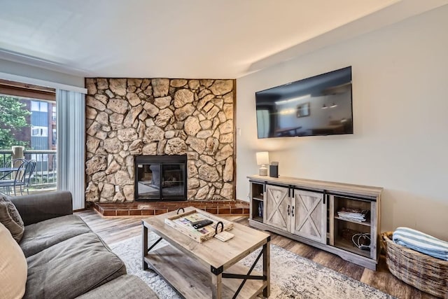 325 Four Oclock Rd Unit E202, Breckenridge, CO 80424 - living area featuring a stone fireplace and wood finished floors