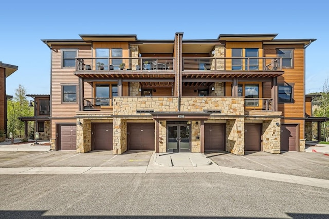 1090 Blue River Pkwy Unit 204, Silverthorne, CO 80498 - view of front of home with a balcony, stone siding, and an attached garage