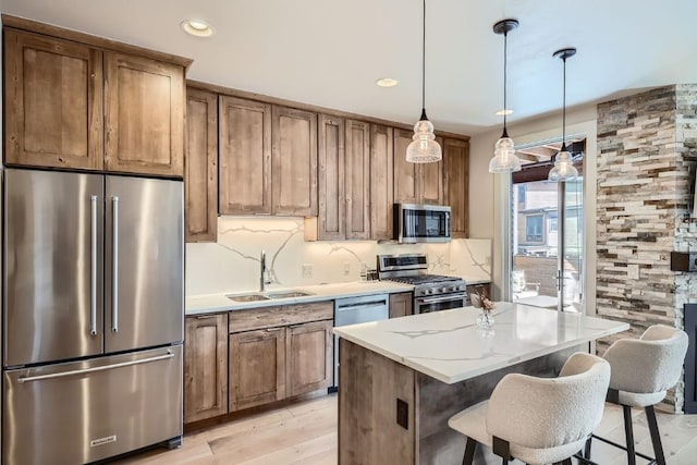 1090 Blue River Pkwy Unit 204, Silverthorne, CO 80498 - kitchen featuring stainless steel appliances, a sink, tasteful backsplash, hanging light fixtures, and a center island