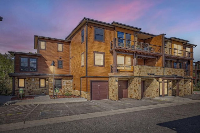 1090 Blue River Pkwy Unit 204, Silverthorne, CO 80498 - property at dusk featuring an attached garage and driveway