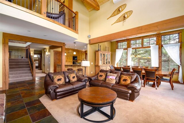 2760 Burgess Creek Rd Unit 2, Steamboat Springs, CO 80487 - living room featuring beamed ceiling, stone tile floors, a high ceiling, and stairs