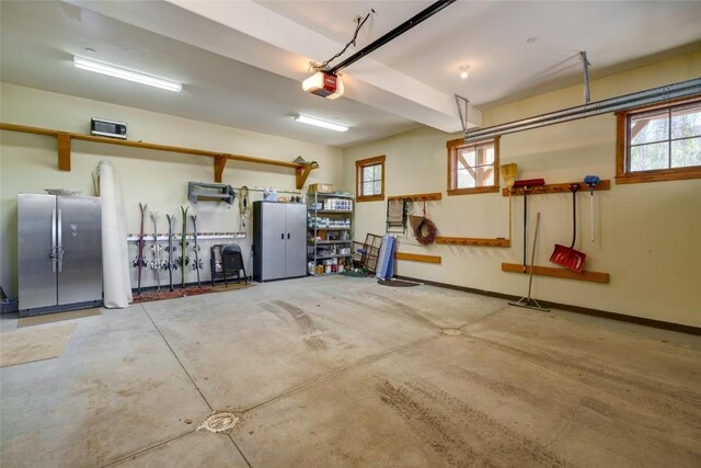 2760 Burgess Creek Rd Unit 2, Steamboat Springs, CO 80487 - garage featuring baseboards, a garage door opener, and freestanding refrigerator