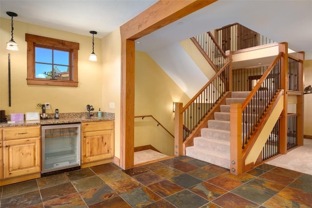 2760 Burgess Creek Rd Unit 2, Steamboat Springs, CO 80487 - bar featuring stairway, stone tile floors, beverage cooler, decorative light fixtures, and baseboards