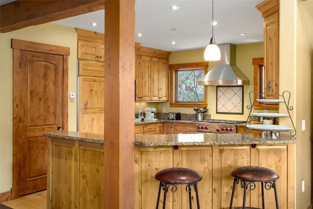 2760 Burgess Creek Rd Unit 2, Steamboat Springs, CO 80487 - kitchen with a peninsula, ventilation hood, a kitchen breakfast bar, range, and hanging light fixtures