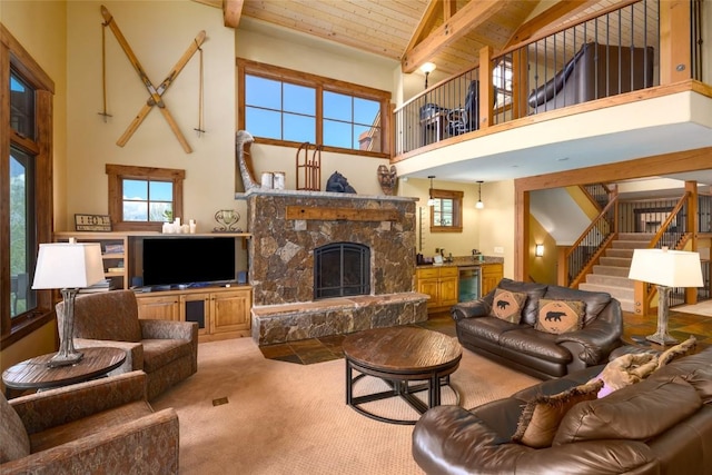 2760 Burgess Creek Rd Unit 2, Steamboat Springs, CO 80487 - carpeted living room with stairway, a high ceiling, beverage cooler, and a stone fireplace
