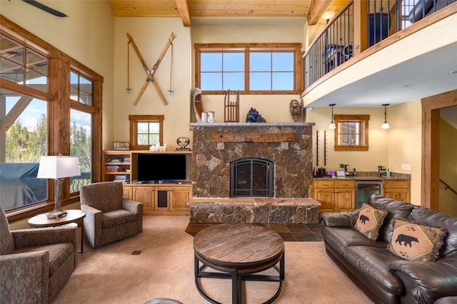 2760 Burgess Creek Rd Unit 2, Steamboat Springs, CO 80487 - carpeted living area featuring a towering ceiling, wine cooler, a stone fireplace, beam ceiling, and wood ceiling
