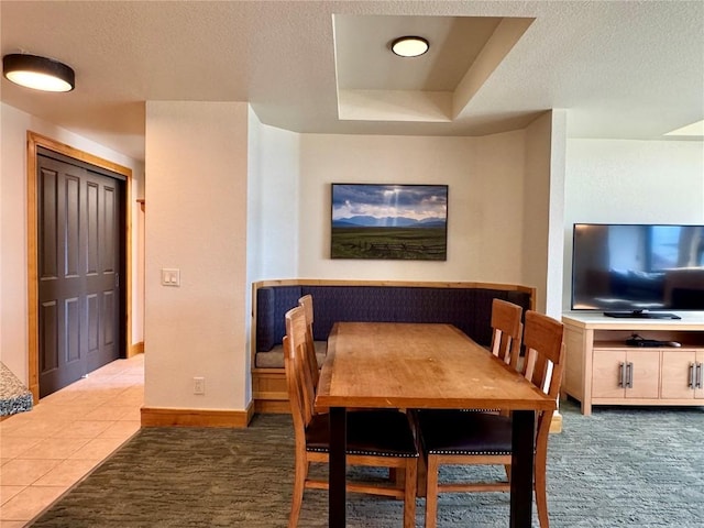2300 Mount Werner Cir Unit 631, Steamboat Springs, CO 80487 - dining space featuring a textured ceiling, a tray ceiling, and tile patterned floors