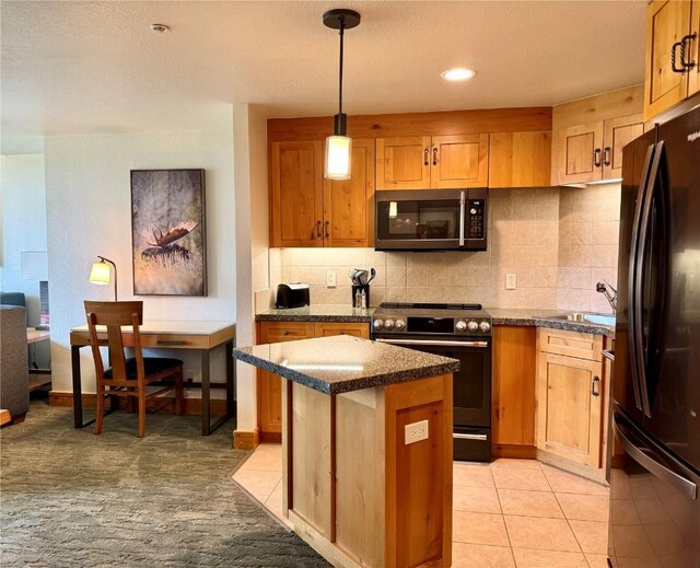 2300 Mount Werner Cir Unit 631, Steamboat Springs, CO 80487 - kitchen featuring stainless steel microwave, electric range oven, freestanding refrigerator, a kitchen island, and decorative backsplash