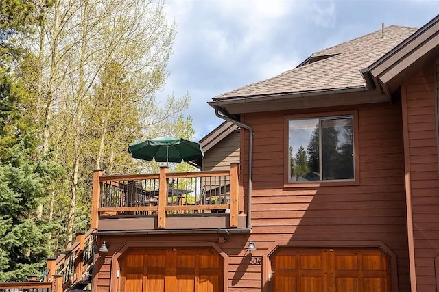 wooden deck with stairway and a garage