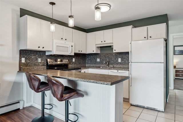 753 Straight Creek Dr Unit 304, Dillon, CO 80435 - kitchen with white appliances, a baseboard radiator, dark countertops, and white cabinetry