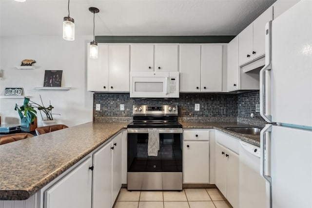 753 Straight Creek Dr Unit 304, Dillon, CO 80435 - kitchen featuring white appliances, a peninsula, light tile patterned floors, and dark countertops