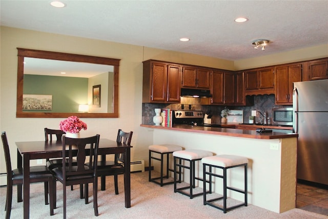 0893 Straight Creek Dr Unit 302, Dillon, CO 80435 - kitchen featuring appliances with stainless steel finishes, under cabinet range hood, decorative backsplash, recessed lighting, and dark countertops