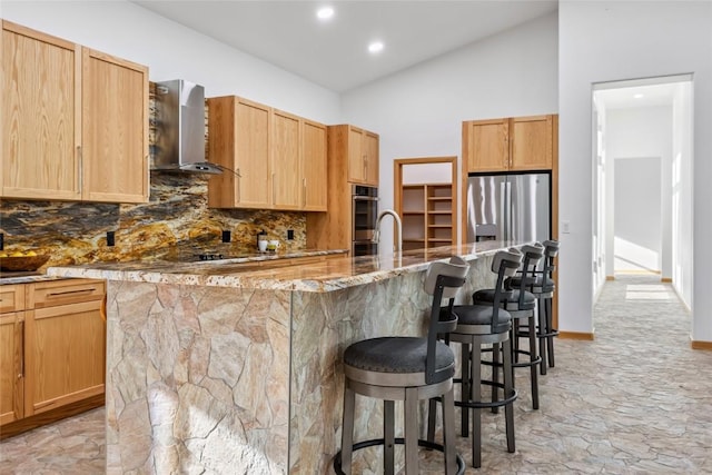 100 Gcr 4104, Granby, CO 80446 - kitchen with stainless steel appliances, wall chimney range hood, backsplash, a kitchen breakfast bar, and light stone counters