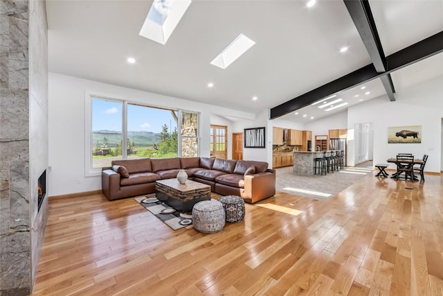 100 Gcr 4104, Granby, CO 80446 - living area with light wood-style flooring, a fireplace, beam ceiling, a skylight, and high vaulted ceiling