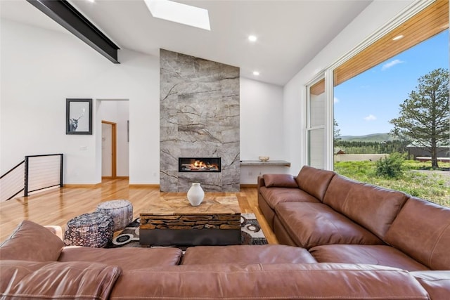100 Gcr 4104, Granby, CO 80446 - living room featuring wood finished floors, a skylight, a fireplace, recessed lighting, and a mountain view