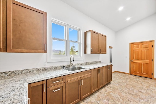 100 Gcr 4104, Granby, CO 80446 - kitchen with lofted ceiling, brown cabinets, light stone countertops, and recessed lighting
