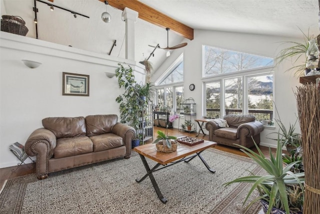 living room with beamed ceiling, wood finished floors, and high vaulted ceiling