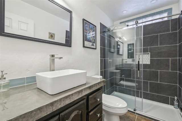 full bathroom with a shower stall, toilet, and vanity
