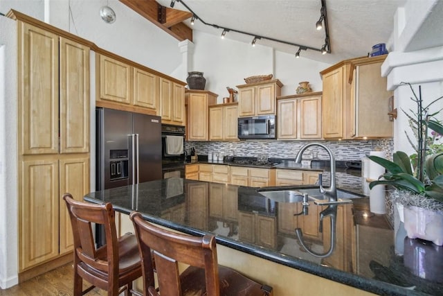 kitchen with dark wood-style floors, stainless steel appliances, backsplash, a sink, and a peninsula