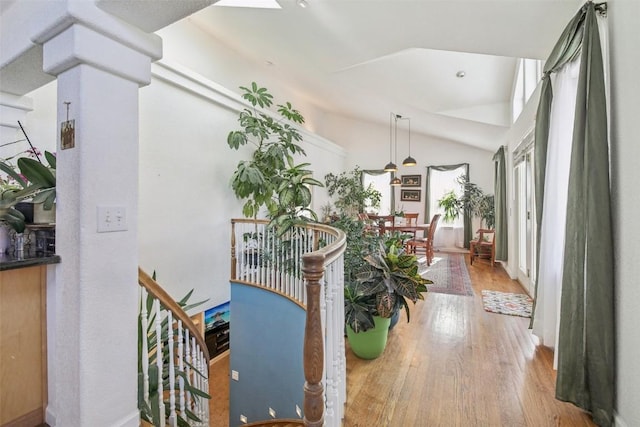 corridor with lofted ceiling and wood finished floors