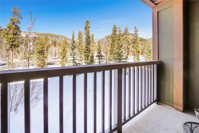 snow covered back of property featuring a view of trees