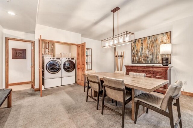 dining area featuring separate washer and dryer, baseboards, and carpet