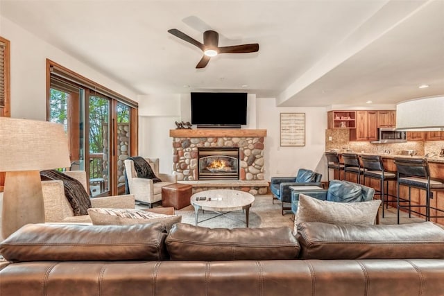 living area with a ceiling fan and a fireplace