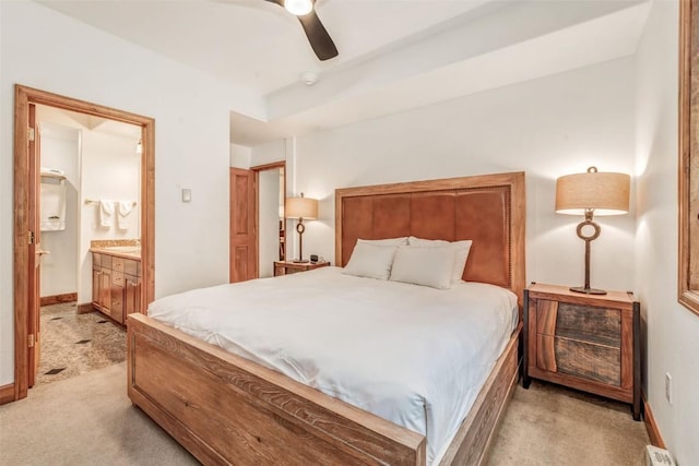 bedroom with ensuite bath, a ceiling fan, baseboards, and light carpet