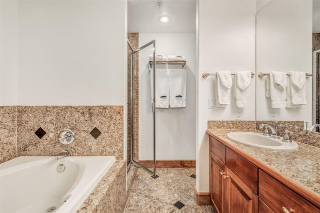bathroom featuring baseboards, a garden tub, vanity, and a shower