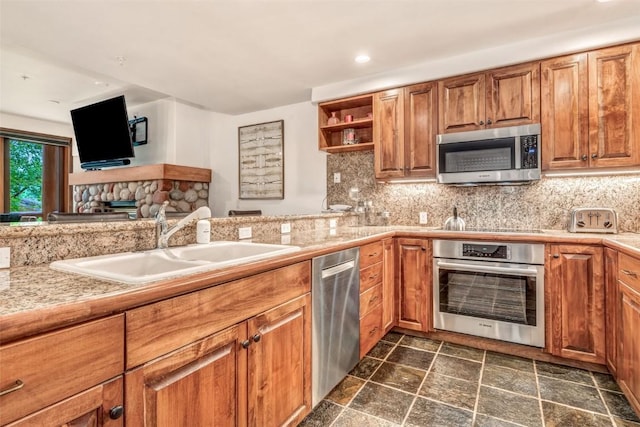 kitchen with stainless steel appliances, a sink, tasteful backsplash, stone finish flooring, and open shelves