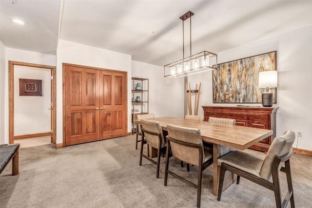 dining space featuring light carpet and baseboards