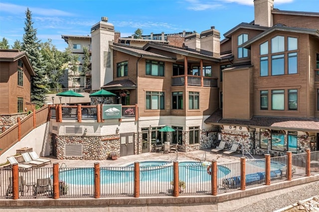 pool featuring fence and a patio area