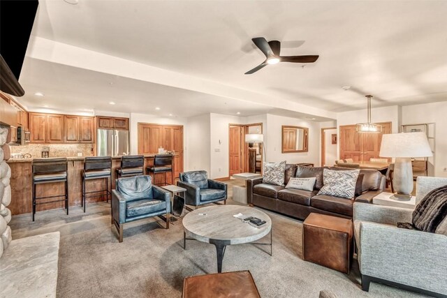 living room with light colored carpet, a ceiling fan, and recessed lighting