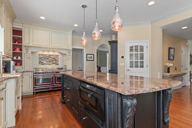 1031 Steamboat Blvd, Steamboat Springs, CO 80487 - kitchen with double oven range, arched walkways, cream cabinets, wood finished floors, and a center island
