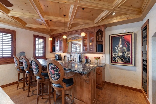 1031 Steamboat Blvd, Steamboat Springs, CO 80487 - indoor wet bar with a wooden ceiling with exposed beams, light wood-type flooring, coffered ceiling, hanging light fixtures, and crown molding