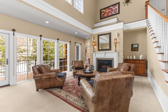 1031 Steamboat Blvd, Steamboat Springs, CO 80487 - carpeted living room featuring a glass covered fireplace, stairs, recessed lighting, and a towering ceiling