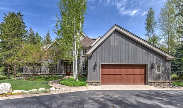 1031 Steamboat Blvd, Steamboat Springs, CO 80487 - view of front of property with an attached garage, stone siding, and driveway